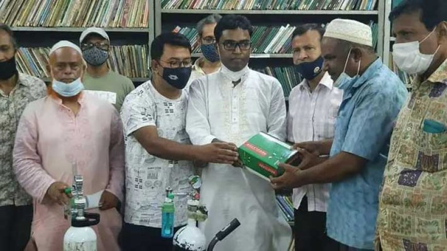 করোনাকালীন স্থানীয় ভিক্টোরিয়া পাবলিক লাইব্রেরিতে বিপন্ন মানুষের সহায়তায় অক্সিজেন সিলিণ্ডার, মাস্ক ও স্যানিটাইজারসহ সুরক্ষা সামগ্রী তুলে দিচ্ছেন নাটোরের মানবিক নেতা এড. এম মালেক শেখ। ছবি: দৈনিক উত্তরপথ।